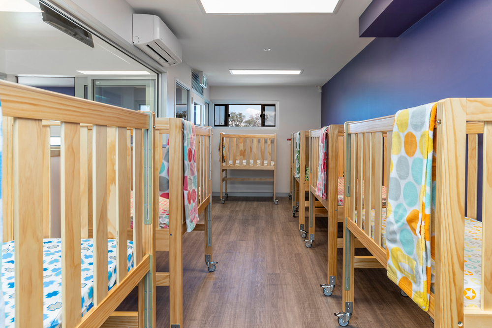 row of cots in nursery at child care centre