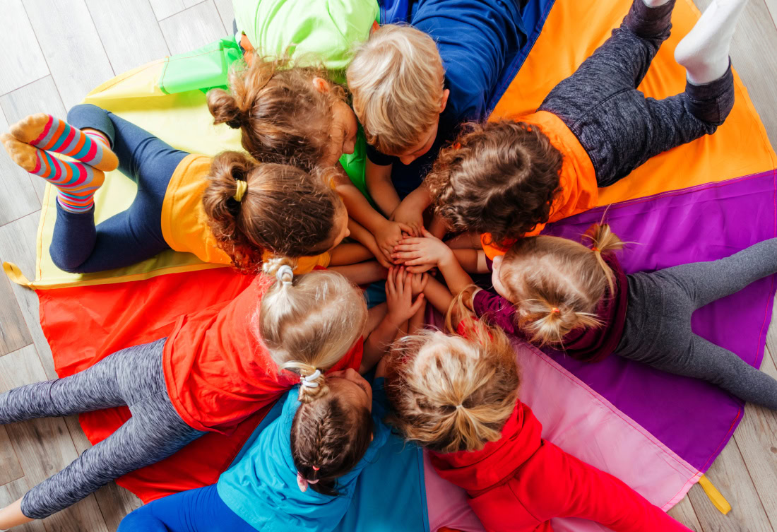 young kids in circle hands in